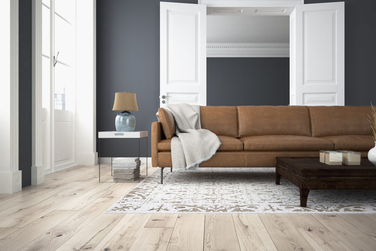 Wohnzimmer mit Ledersofa, Teppich und Dielenboden