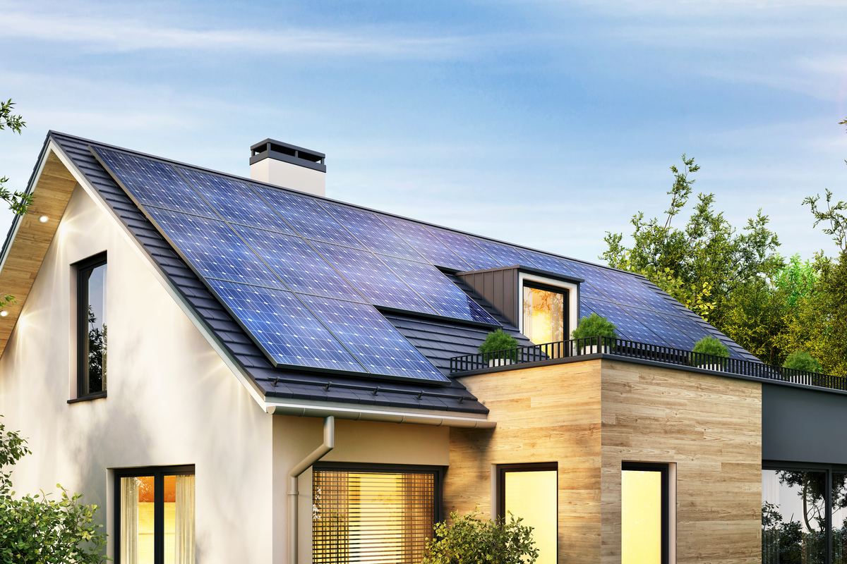 Modernes Wohnhaus mit Photovoltaikanlage auf dem Satteldach im Abendlicht